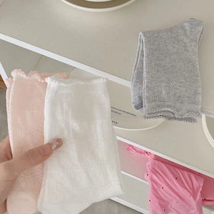 Détail du bord à volants et du motif résille sur les chaussettes en coton