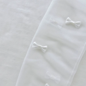 Detail of white semi-transparent mesh socks with sweet bow accents in ballet style