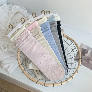 Close-up of pastel nep yarn socks with ribbed texture and decorative cardboard header tags