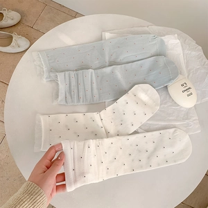 Close-up of lace mesh socks with polka dots featuring ruffled edge details