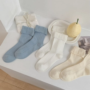 Détail de la maille tricotée de chaussettes respirantes en crème, blanc et tons bleus