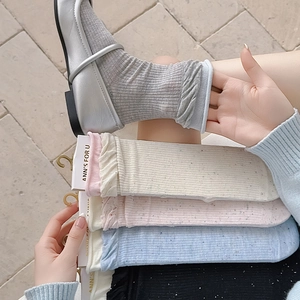 Close-up of ribbed cotton crew socks with wavy frill cuffs in Morandi pastel colors