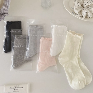 Détail de chaussettes à bord volanté et maille cœur en plusieurs coloris avec emballage