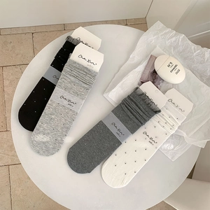 Detailed view of four-color lace mesh socks with polka dots and ruffled edges in a set