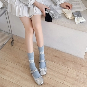 Detail of ribbed cotton socks with lace trim and vintage labels worn with Mary Janes