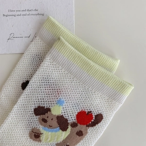 Close-up of mesh knit socks featuring cute cartoon dog patterns and green ribbed cuffs