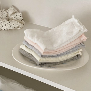 Détail de cinq paires de chaussettes en maille ajourée avec bords à volants doux