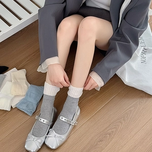 Détail de chaussettes grises en maille ajourée avec bord en dentelle et chaussures