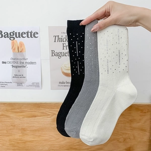 Detailed view of three-pack cotton socks in black, gray, and white with rhinestone embellishments