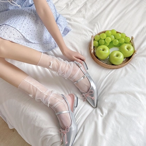 Detail of sheer white Lolita tulle socks with bow accents paired with silver Mary Jane shoes