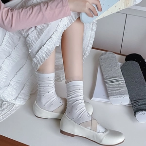 Close-up of women's lace mesh tulle socks with polka dots and ruffled edges for Mary Janes