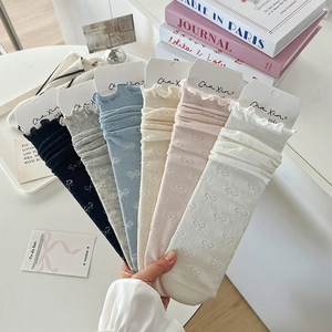Detail showing variety of six pastel socks with delicate ruffles and bow jacquard patterns