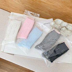 Detailed view of rhinestone studded socks in five colors with premium packaging