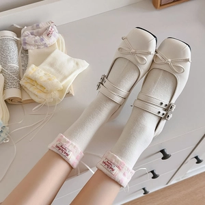 Détail de chaussures Mary Jane blanches à double bride et chaussettes à volants roses