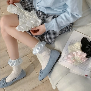 Detailed macro view of girls' cotton socks featuring lace ruffles and knit patterns