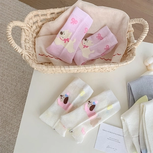 Detail of pink and white mesh baby socks with cute puppy patterns in a woven basket