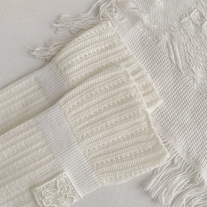 Detailed macro view of white ribbed knit socks featuring delicate scalloped lace edges