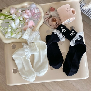 Detailed view of lace trim socks with pearl bow accessories in black and white colors