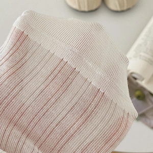 Gros plan sur la maille côtelée respirante montrant une texture semi-transparente et élastique