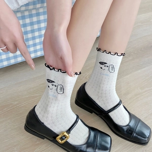 Detail of white cotton sock with cartoon dog embroidery and black wavy lettuce trim edge