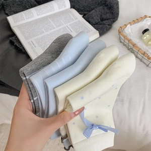 Close-up of cute Japanese style cotton socks with blue bows and soft ruffle details