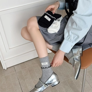 Gros plan de chaussettes à froufrous noir, blanc et gris avec étiquettes de style
