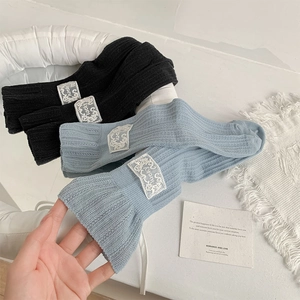 Detail of knit crew socks with Lucky label and vertical ribbing in black and light blue