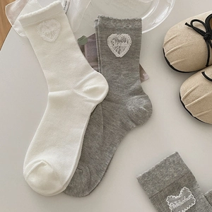 Détail de l'écusson en dentelle cœur et revers ondulés sur chaussettes respirantes