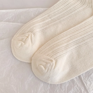 Detail of off-white cotton socks with vertical ribbing and breathable mesh knit texture