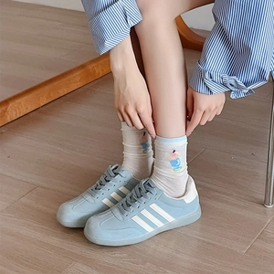 Detailed shot of white cotton socks featuring a colorful dessert embroidery detail