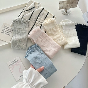 Detailed view of ruffle cuffs and bow jacquard patterns on colorful cotton socks