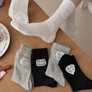 Détail de chaussettes en coton avec dentelle en forme de cœur et texture tricotée
