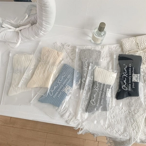 Detailed view of ribbed knit mid-calf socks in various colors with zip-lock packaging