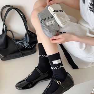 Détail de chaussettes en coton avec bords à volants et étiquettes en dentelle KIKI SOX