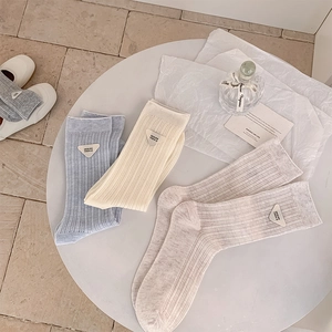 Detailed knit texture of rib-cuffed cotton socks with triangular fashion labels