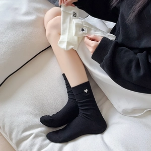 Close-up of heart embroidery and letter label on mid-calf knit cotton socks