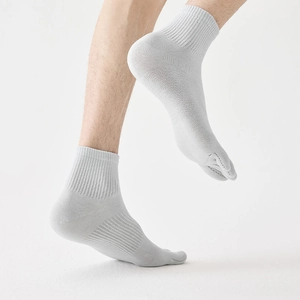Macro detail of breathable grey mid-calf toe socks with arch support and ribbed cuffs