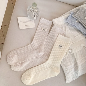 Detailed view of ribbed mid-calf socks with triangular design trend logo patches