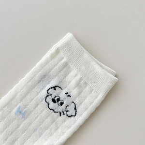 Close-up of white cotton socks featuring cute cartoon dog embroidery and ribbed cuffs
