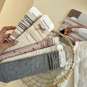 Détail de chaussettes assorties de style doux avec nœuds et motifs en tricot