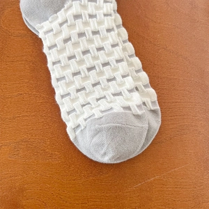 Detailed close-up of textured checkered pattern on contrast color cotton crew socks