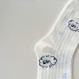 Close-up of white rib-knit crew sock featuring cartoon cloud and blue letter jacquard detail