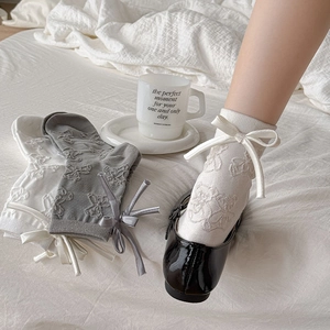 Detail of cute bear embroidery and satin bow on Japanese style white calf socks