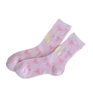Cute pink mesh socks with bow patterns and rabbit patch in a minimalist studio layout