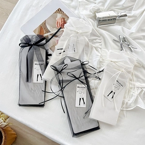 Detailansicht von transparenten Netzsocken mit Schleifen in eleganter Organza-Verpackung