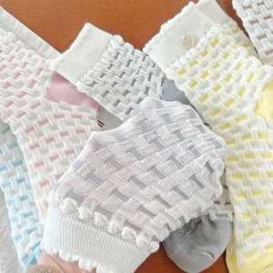 Close-up of breathable checkered mesh socks with scalloped lace edges and button details
