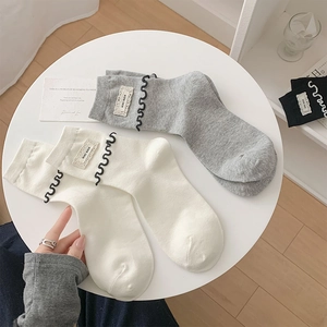 Détails de chaussettes en tricot avec bords à volants et étiquettes de marque KIKI SOX