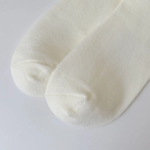 Vista macro della trama a maglia fitta e cucitura della punta di calze di cotone bianco