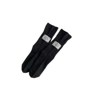 Black ribbed knit socks with lucky patch detail in a minimalist aesthetic