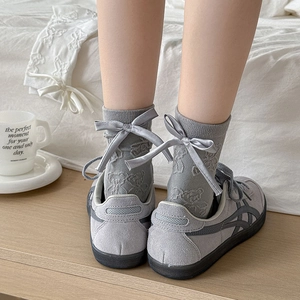 Detail of grey calf socks featuring 3D bow and bear jacquard pattern in Japanese style